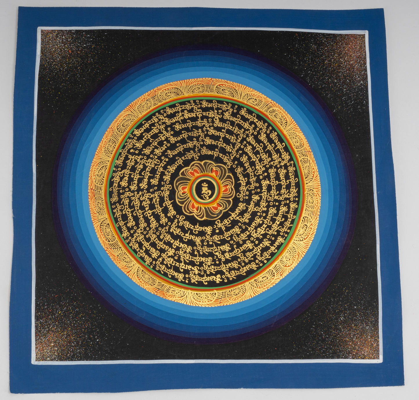 Handgemaltes Mantra-Mandala aus Nepal 30 x 30 cm auf handgemachter Canvas Leinwand, blaue und goldenen Umrandung um goldene Schrift auf schwarzem Hintergrund, Lotusblüte mit einem Om Zeichen im Zentrum